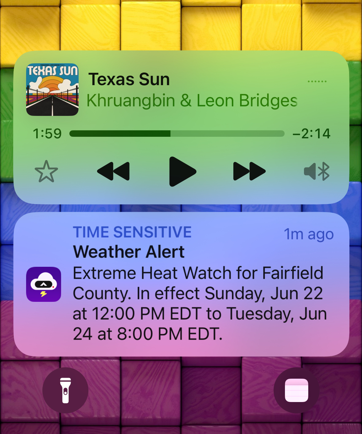 A Lock Screenshot with two items displaying. One shows the current playing song: “Texas Sun” by Khruangbin & Leon Bridges. The second one is an Extreme Heat watch alert. 